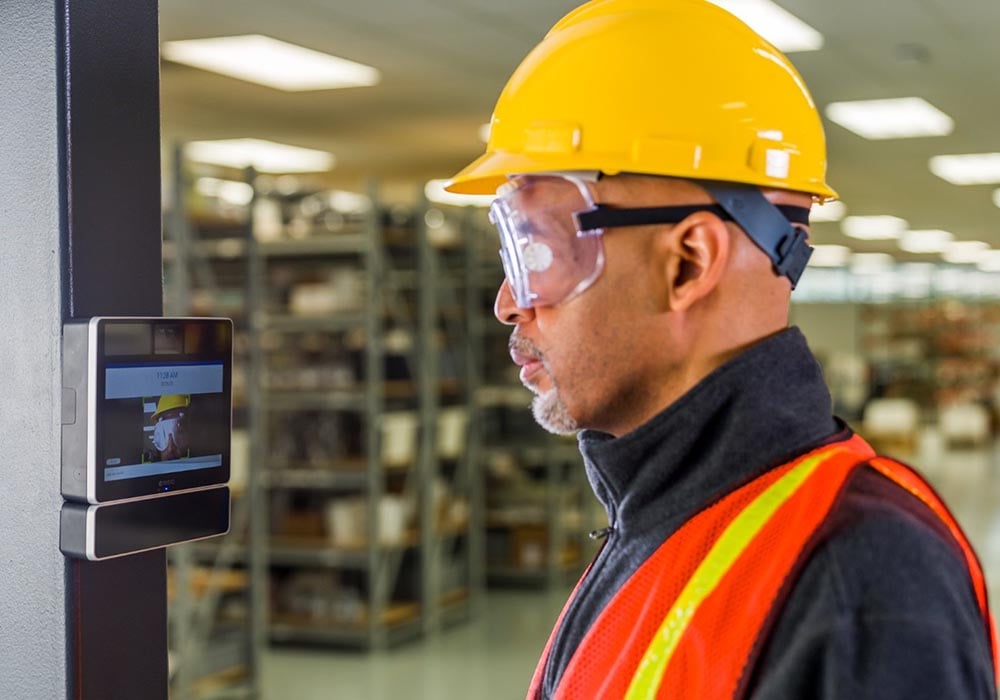 a factory worker using paychex iris time clock to clock in