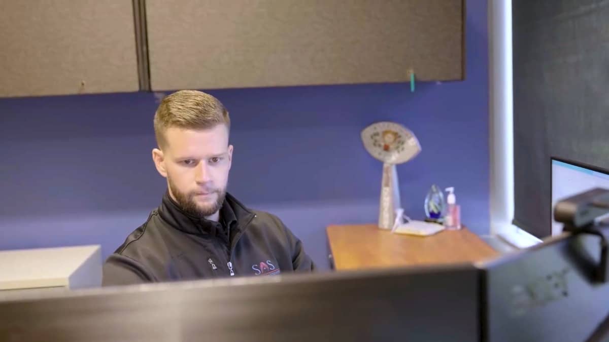 Male CPA with beard works on computers