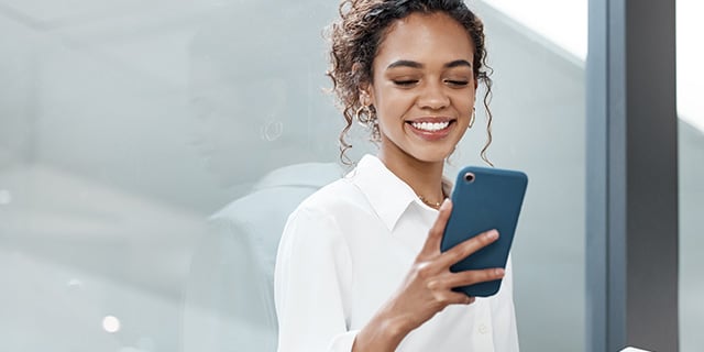 satisfied employee smiling while checking her payment on cellphone