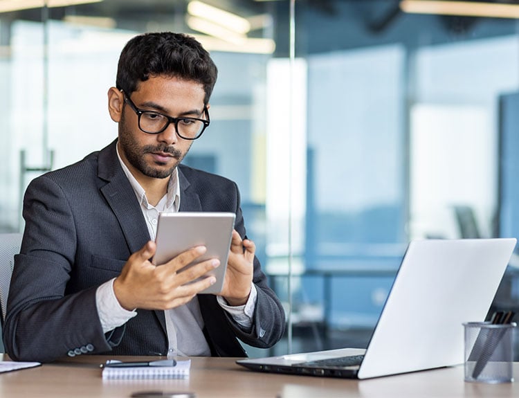 man working on laptop and tablet 