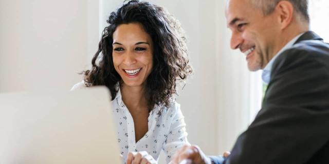 woman and man looking at computer screen together 