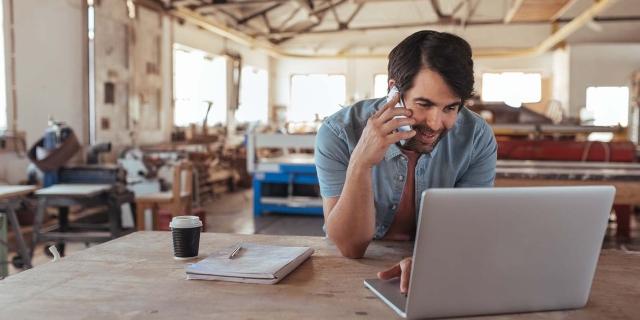 a small business owner researching on his laptop health insurance options for his employees