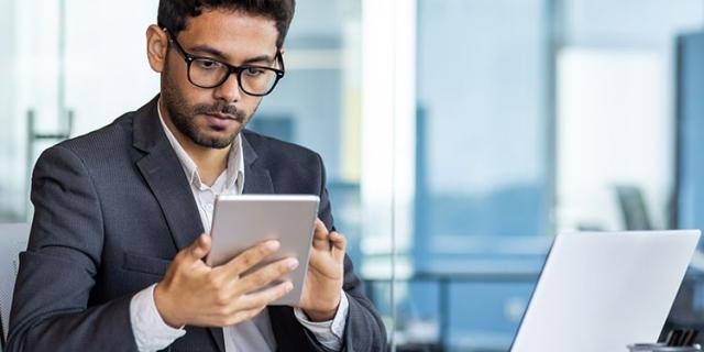 man working on laptop and tablet 