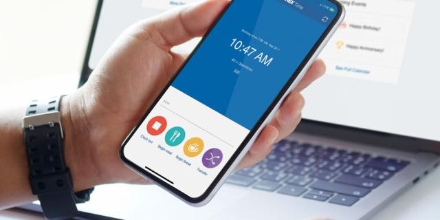 person looking at paychex flex payroll on cellphone and laptop
