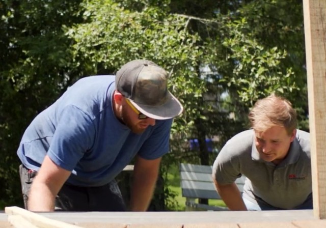 2 men inspect wooden deck