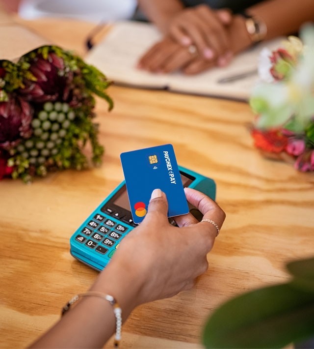 A customer paying for flowers with her Paychex Pay card