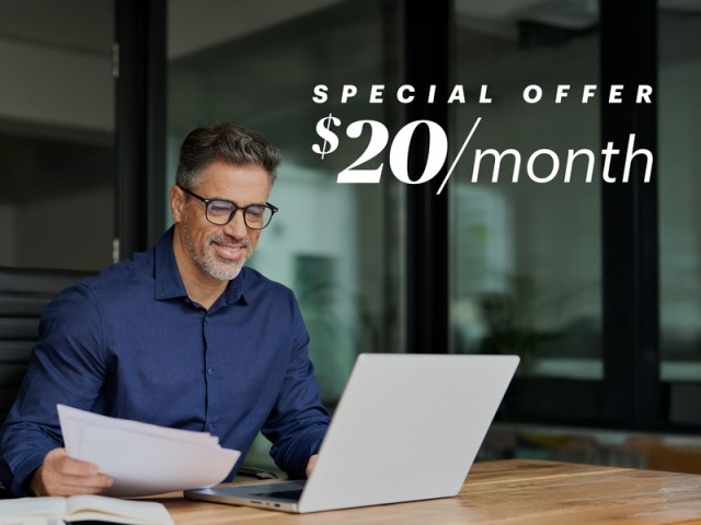 A business owner working on his laptop in an office with a text overlay that says "special offer $20 / month"