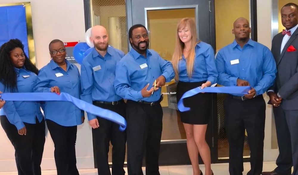 Paul Bolden, with scissors, cuts the ceremonial ribbon when he opened his new insurance office in the Dallas area.