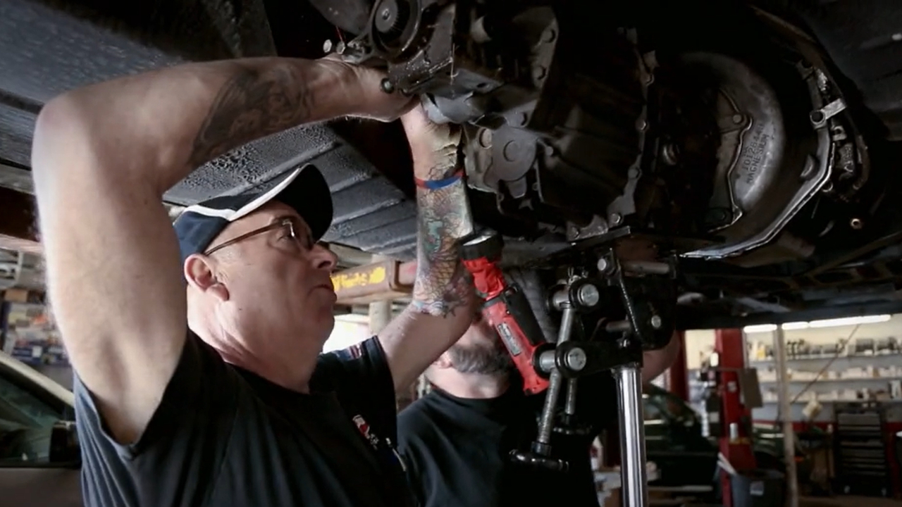 mechanic fixes underbody of automotive
