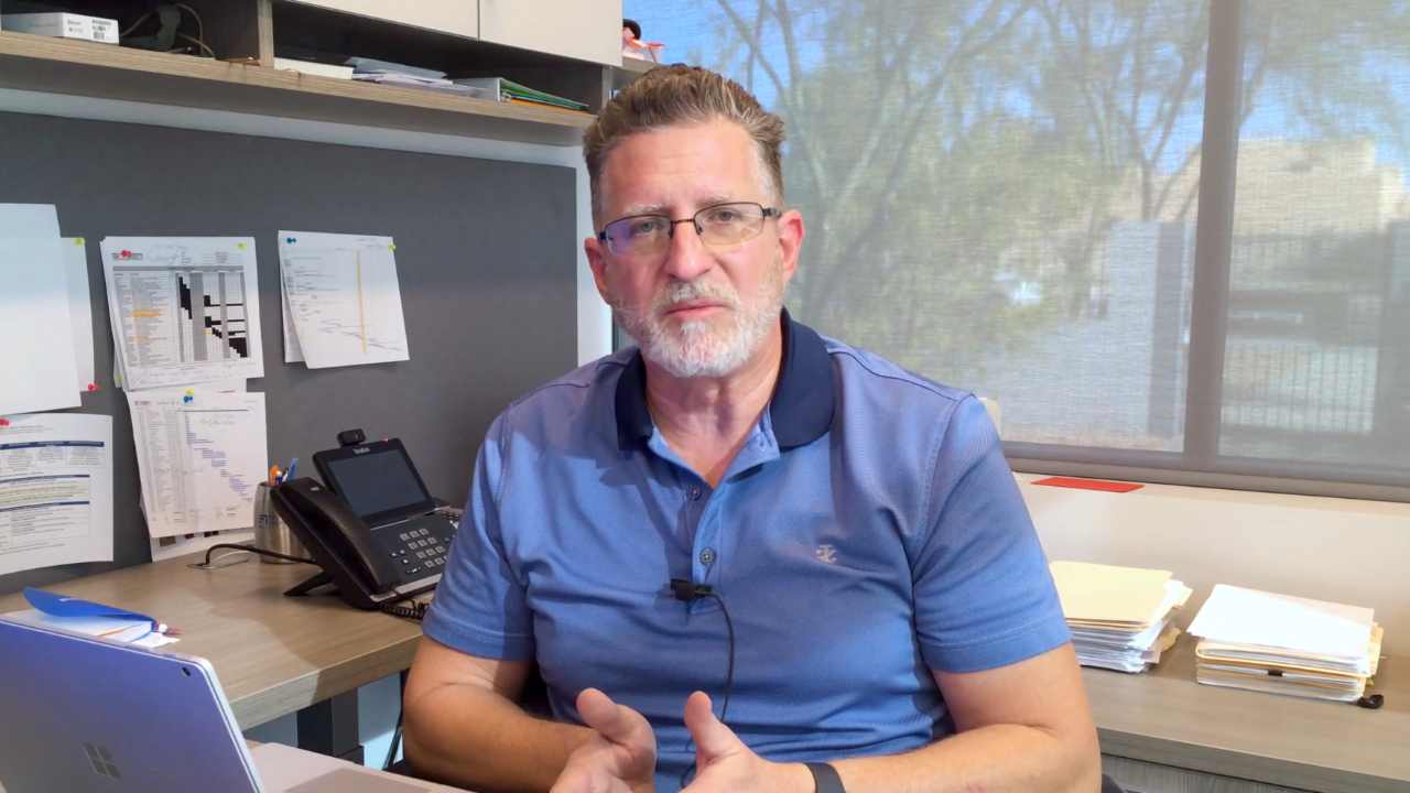man at desk describes business service solution 