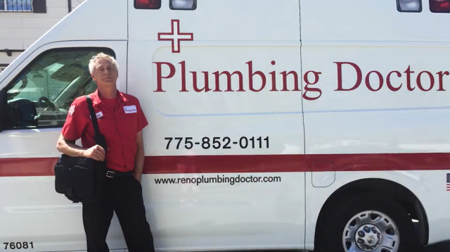 man in red shirt stands next to service truck that reads "Plumbing Doctor" on the side
